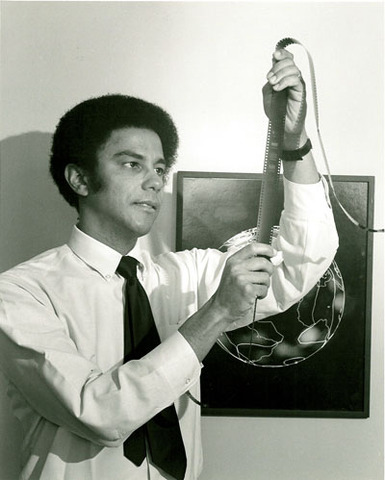 Photograph, Warren Washington viewing climate model output on microfilm